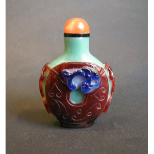 Glass snuff bottle overlay 3 colors on green carved and decorated with a coin